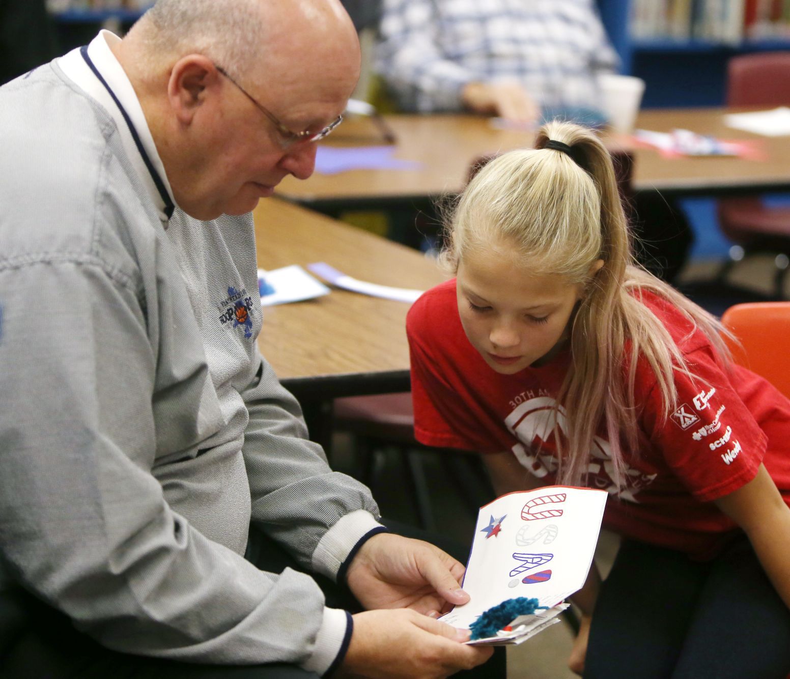 Larry Richardson looks at his handmade thank you cards with his granddaughter Ramsey Biehl